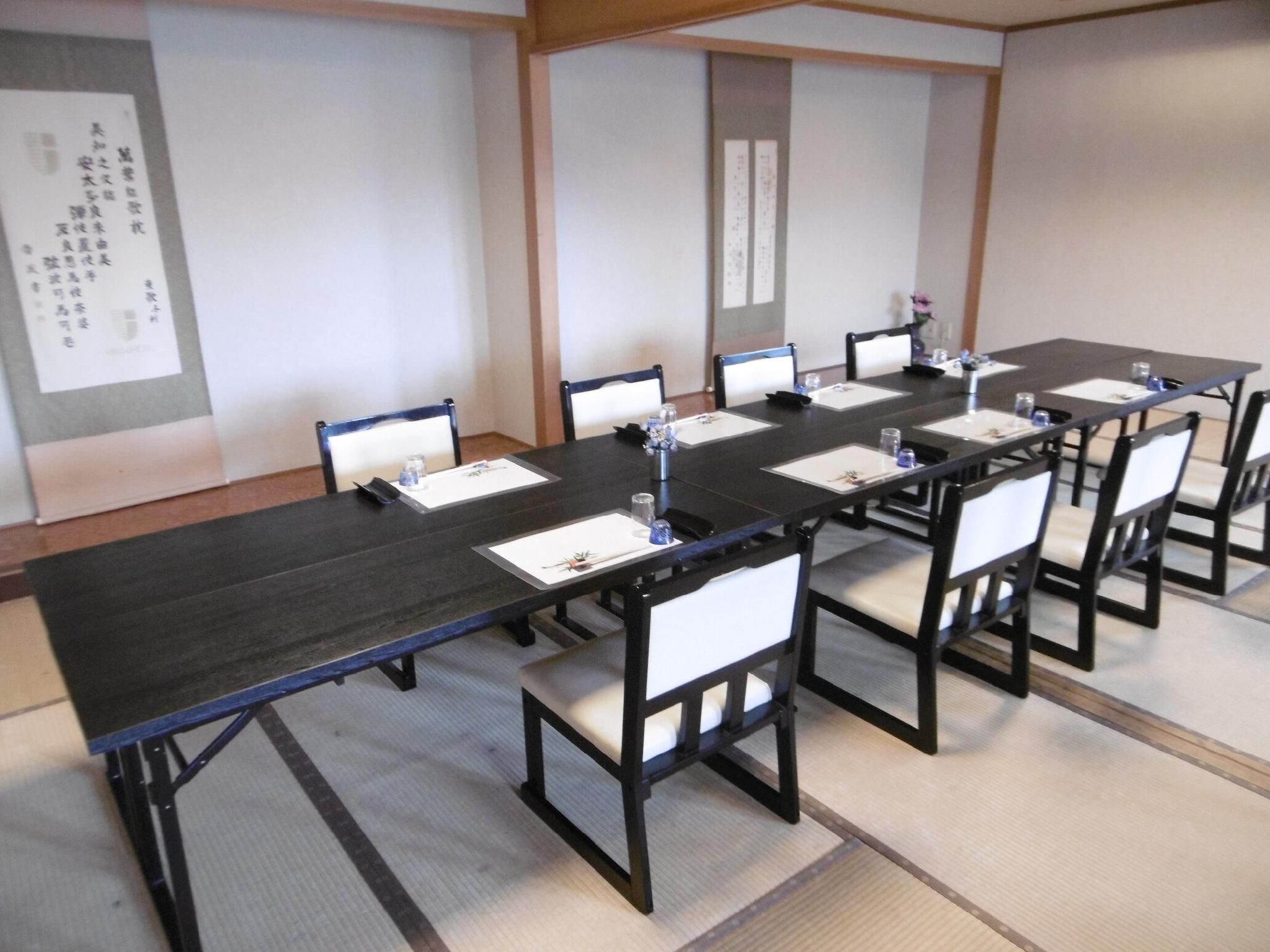 A conference room with a long table, chairs, and a whiteboard.