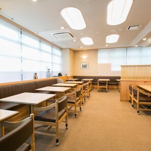 A restaurant with booths, tables, and chairs. - Yokkaichi City Hotel Annex (Yokkaichi)