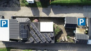 An aerial view of a parking area with solar panels and a covered seating area. - Lovely home in Otterup with WiFi (Otterup)