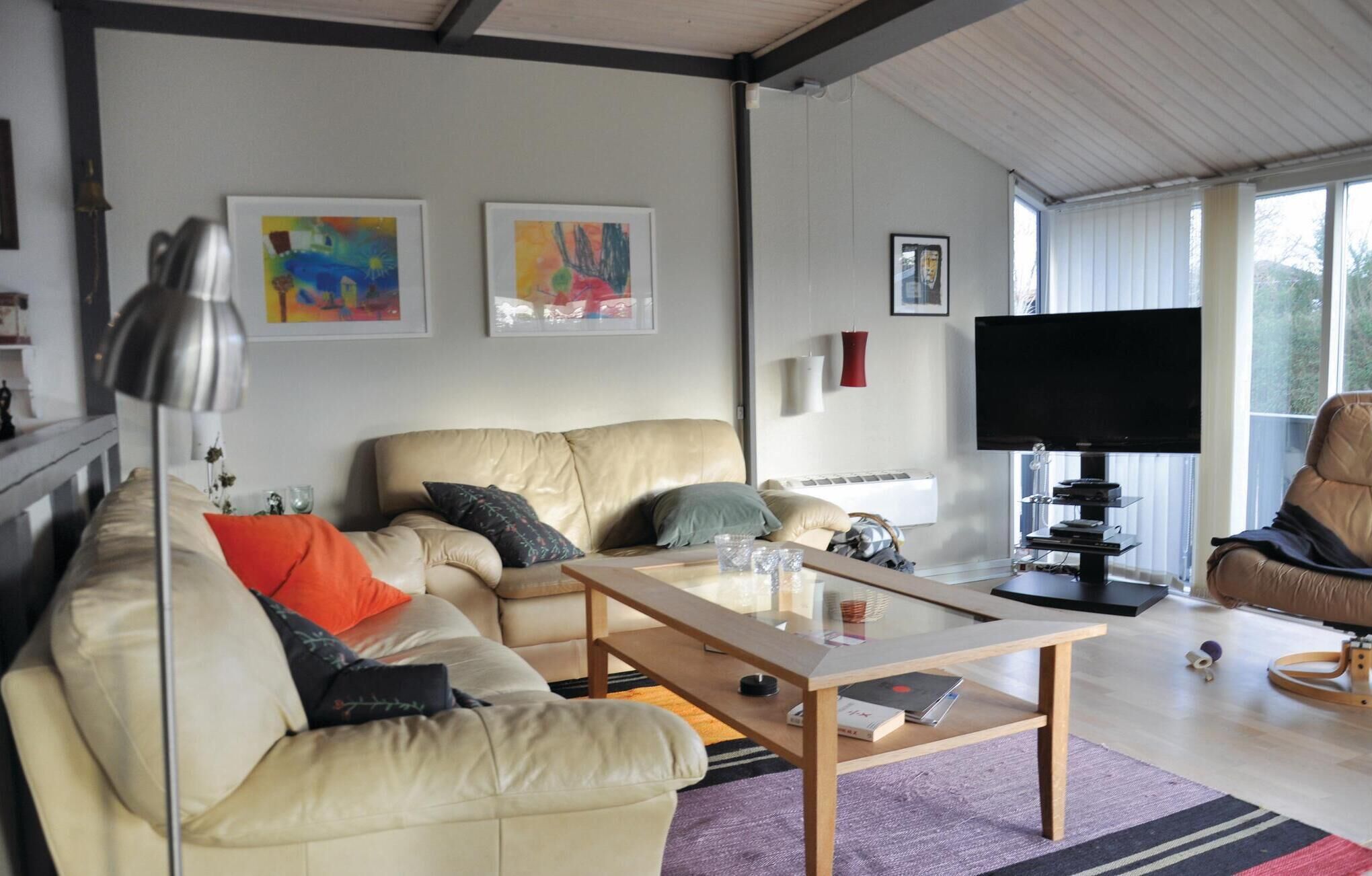 A modern living room with a sofa, coffee table, and a flat-screen TV.
