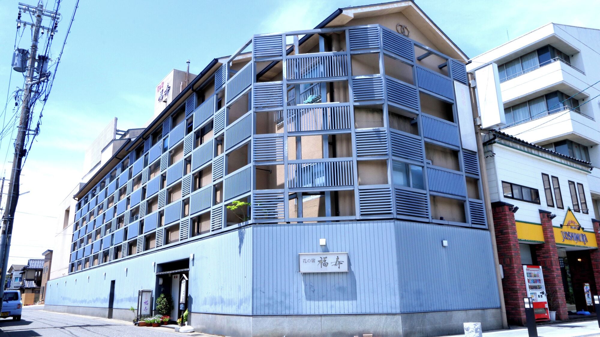 A multi-story hotel with a modern architectural design, featuring balconies and a visible entrance.