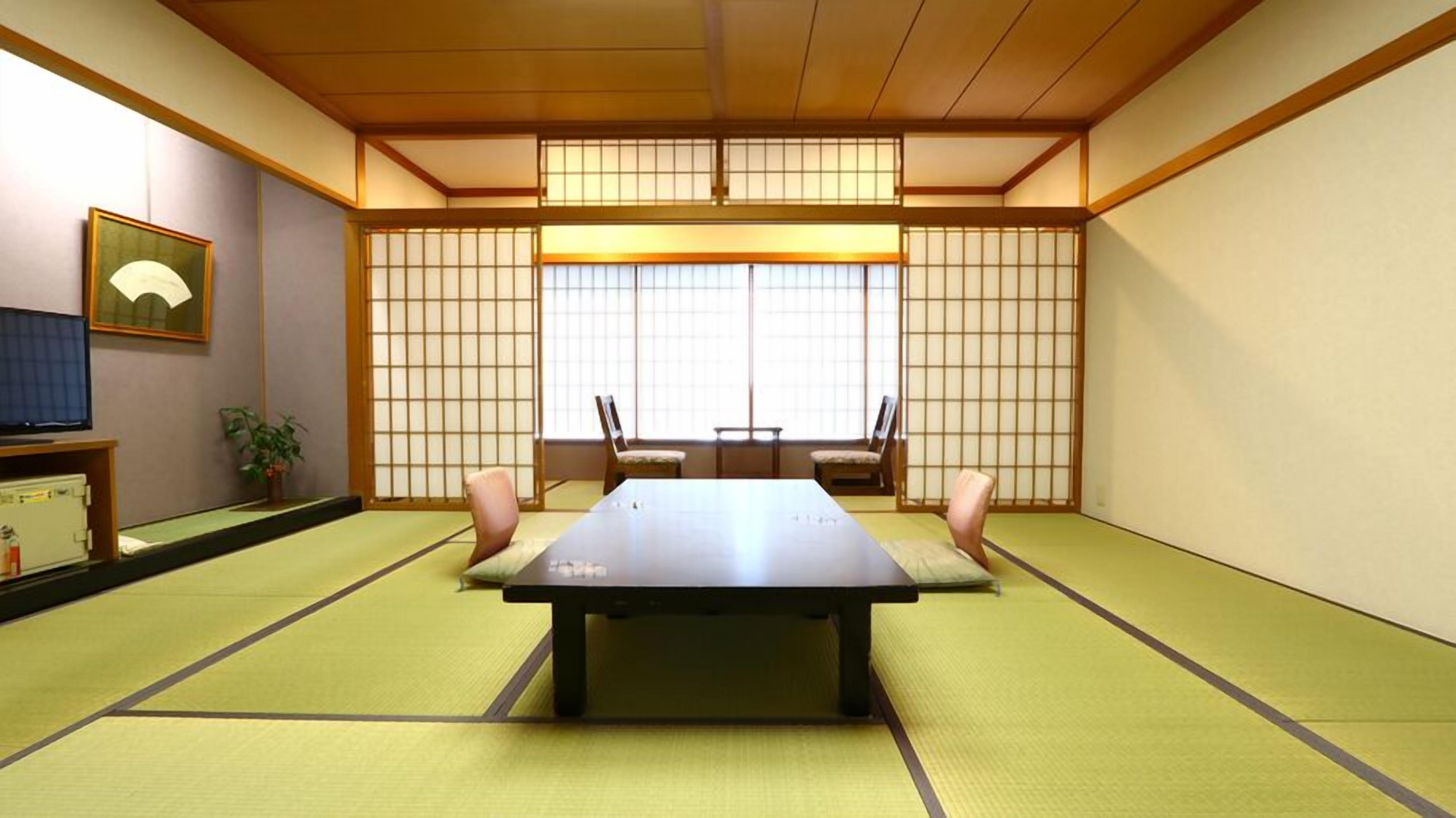 Habitació japonesa tradicional amb fons de tatami, una taula baixa i portes corredisses.