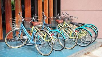 A row of bicycles parked outside a building with a tiled floor.