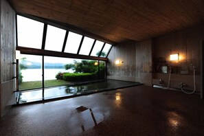 A spacious room with a large window, a shower area, and a view of a lake. - Wakasamikata Kirara Onsen Hotel Suigekka (Wakasa)
