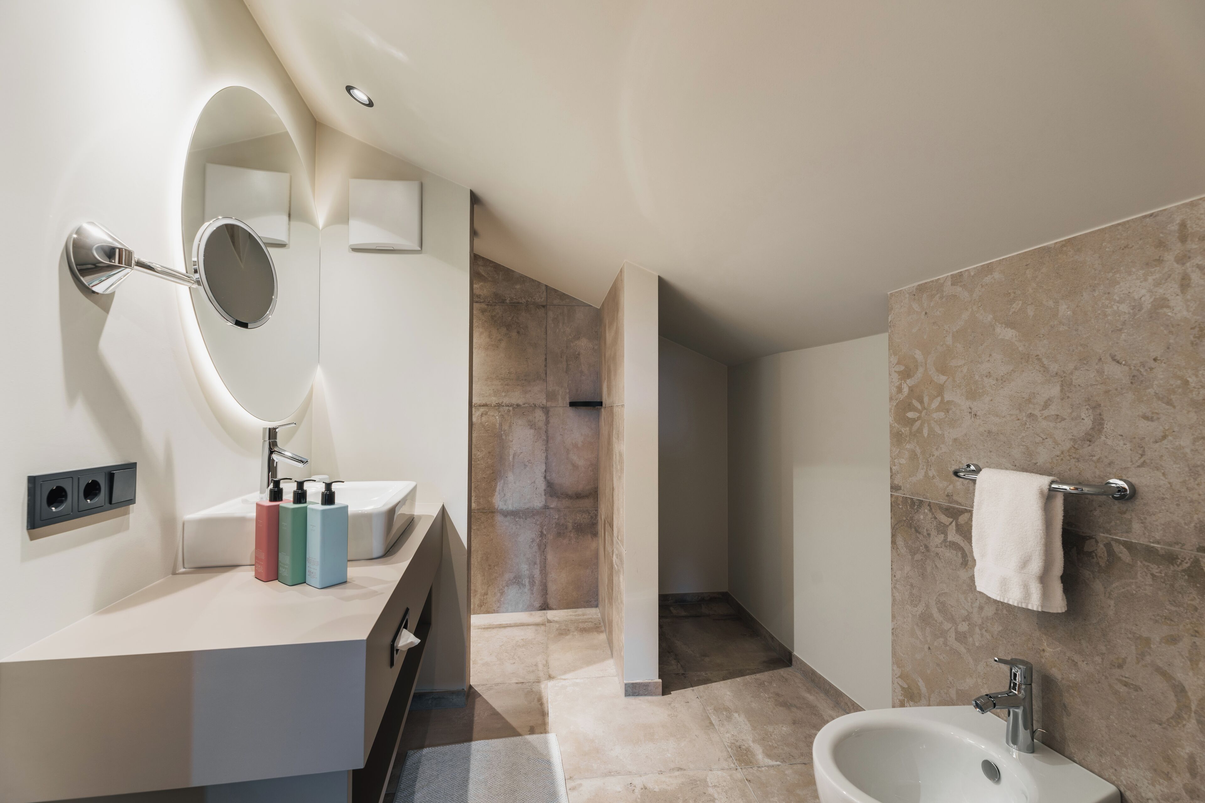 Un baño moderno con tocador, lavamanos, espejo y bidé.
