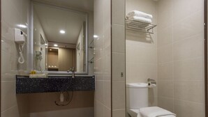 A modern bathroom with a glass-enclosed shower, a sink with a mirror, and a toilet with a towel rack above it. - Hotel Holmes GP (Gelang Patah)