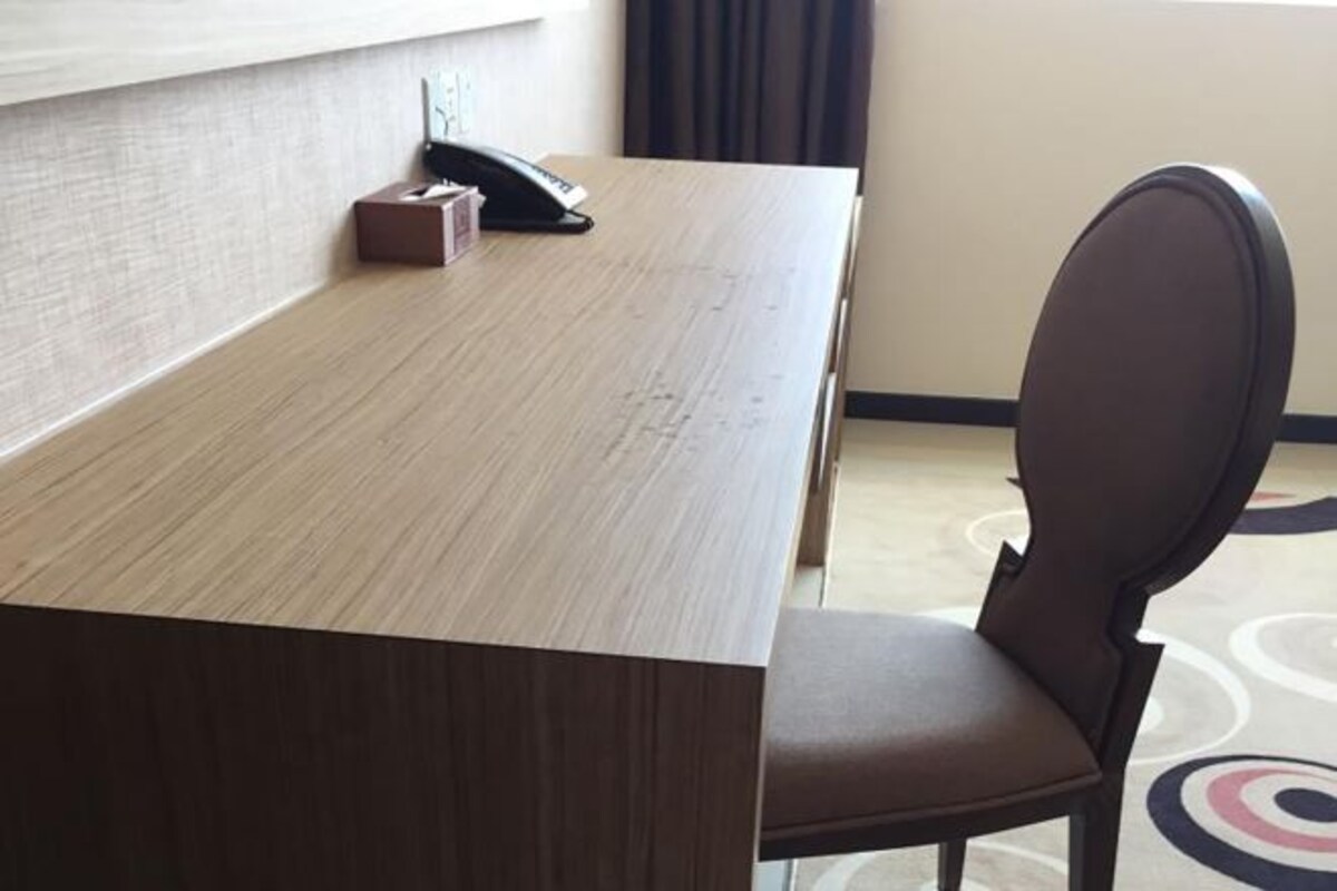 A conference room with a long table, a telephone, and a chair.