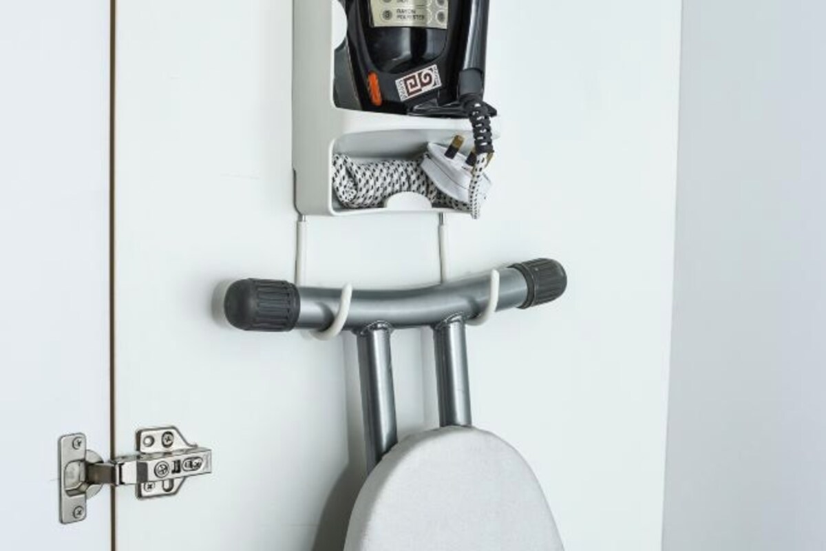 A white door with a silver handle, a black and white patterned towel, and a black object on the towel.
