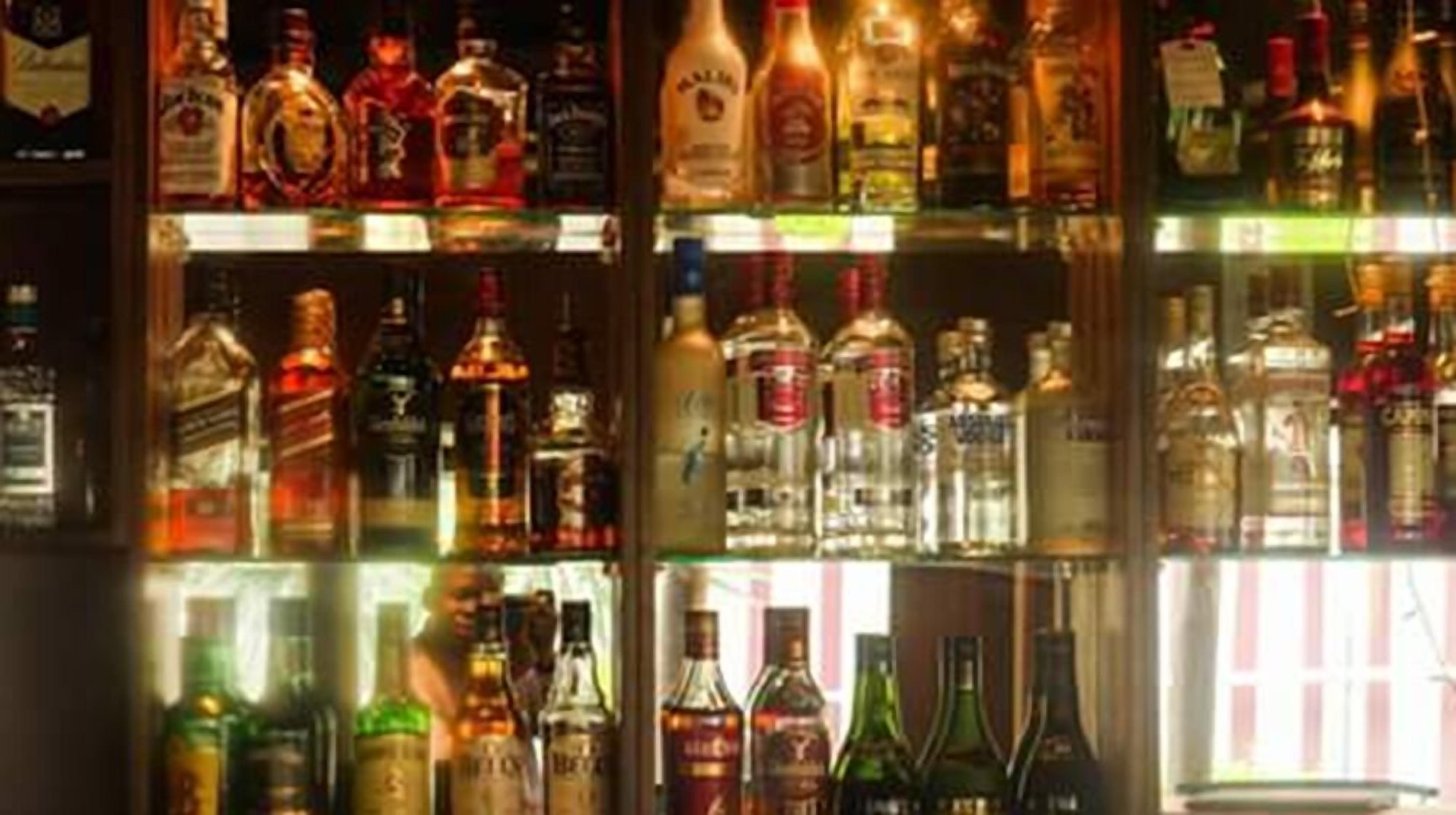 A bar area with various liquor bottles displayed on shelves.