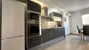 A modern kitchen with stainless steel appliances, grey cabinetry, and a tiled floor. - Drugstore B A - Two Bedroom Apartment, Sleeps 6 (Roses)