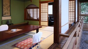 Ein traditioneller japanischer Raum mit Tatami-Böden, einem niedrigen Holztisch und Schiebetüren.
