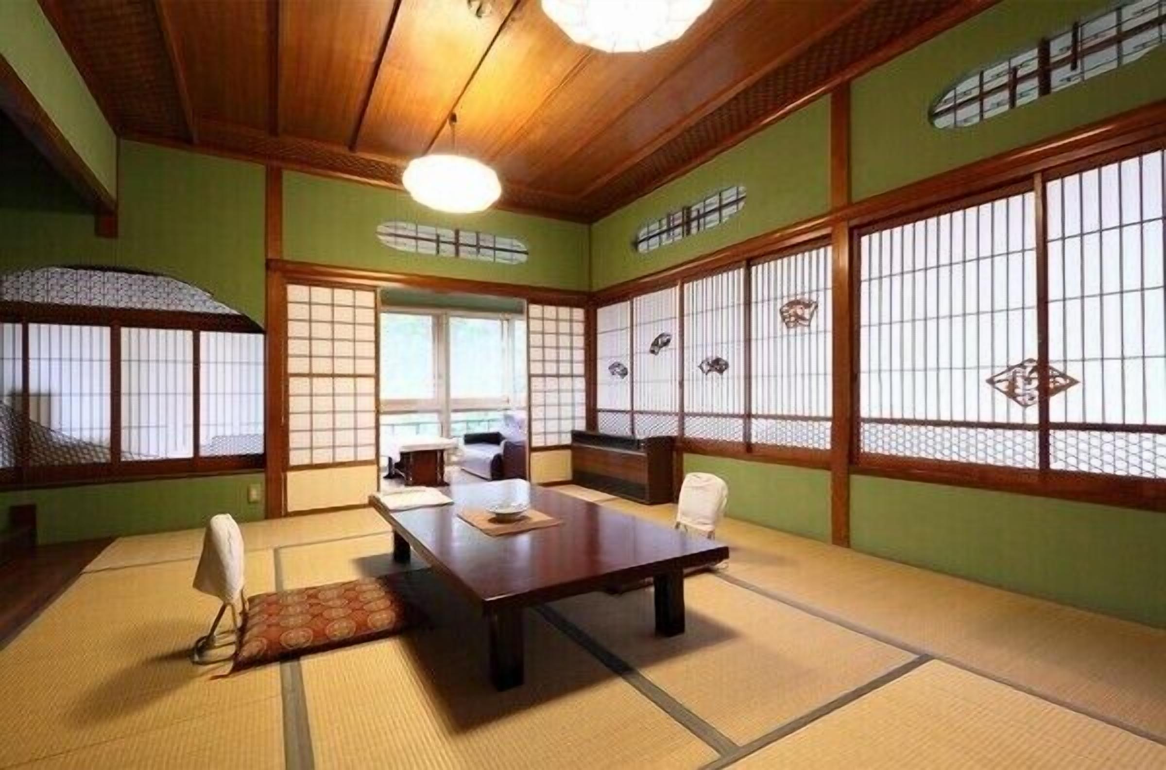 A traditional Japanese room with tatami flooring, a low wooden table, and shoji screens.