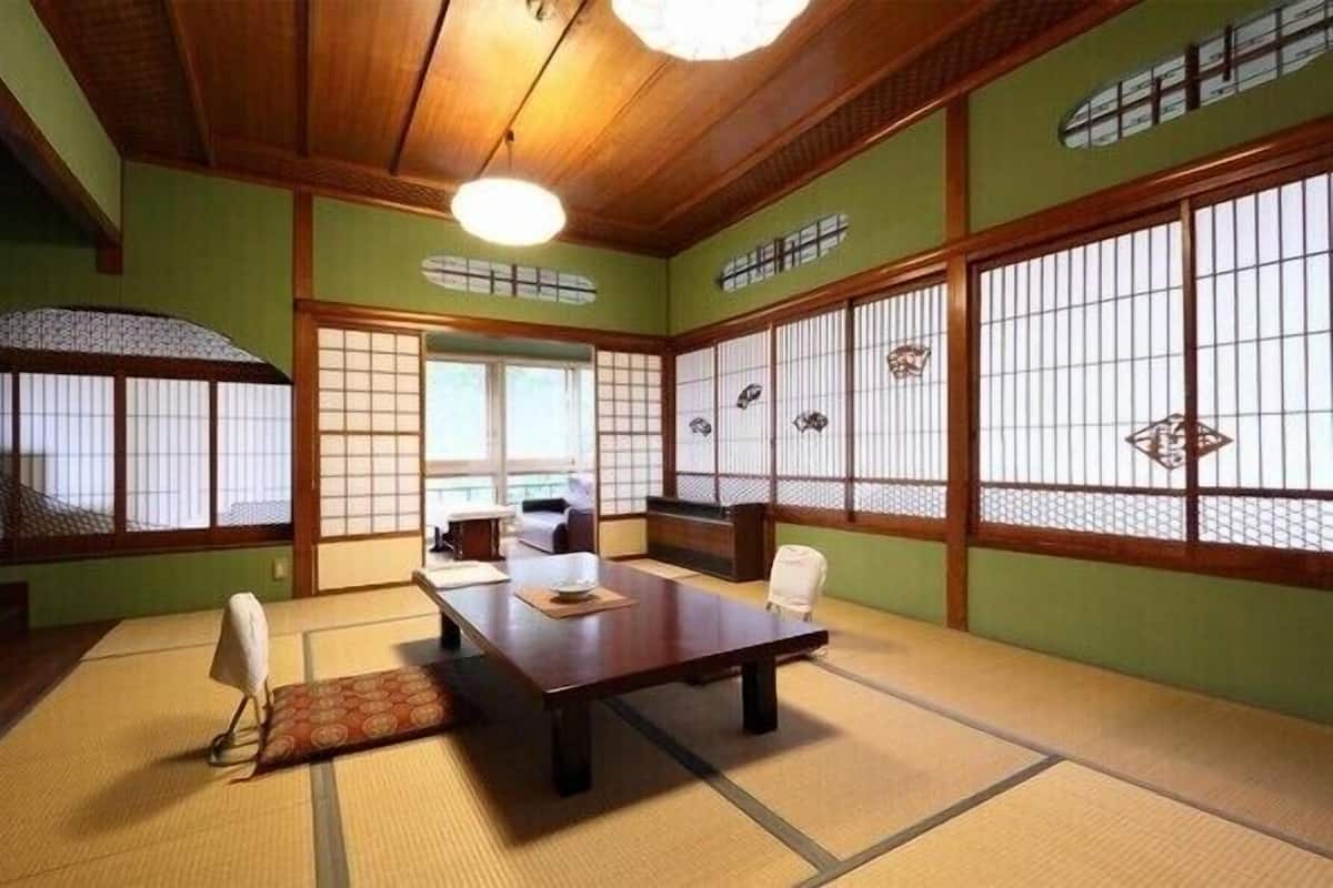 Une pièce de style japonais traditionnel, avec un sol recouvert de tatamis, une petite table en bois et des paravents en papier de riz (shoji).