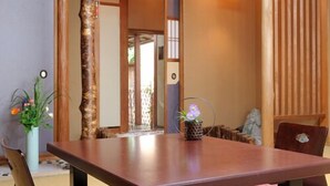 Une pièce de style japonais traditionnel, avec un sol recouvert de tatamis, une basse table en bois et un banc rembourré.