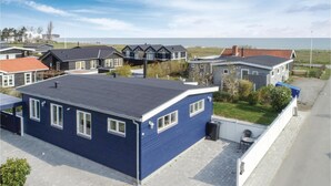 Un quartier résidentiel avec des maisons, une route goudronnée et une vue sur la mer.