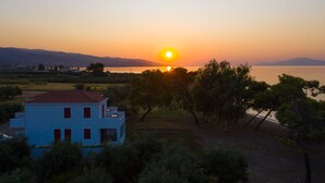 A coastal property with a two-story building, a view of the sea, and a sunset. - Makis Inn Resort (Ermionida)