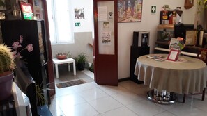 A hotel lobby with a round table, a small white table, and a potted plant.