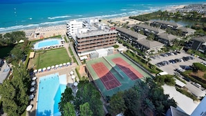 An aerial view of a hotel with multiple swimming pools, a tennis court, and a beach area. - Hotel President (Silvi)