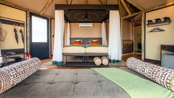 A room with a bed, two sofas, a hanging light fixture, and a ceiling fan.