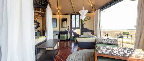 A spacious room with a large bed, a dining area, and a view of the outdoors.