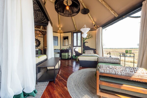 A spacious room with a large bed, a dining area, and a view of the outdoors.
