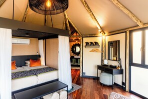A bedroom with a bed, bedside table, and a hanging light fixture.