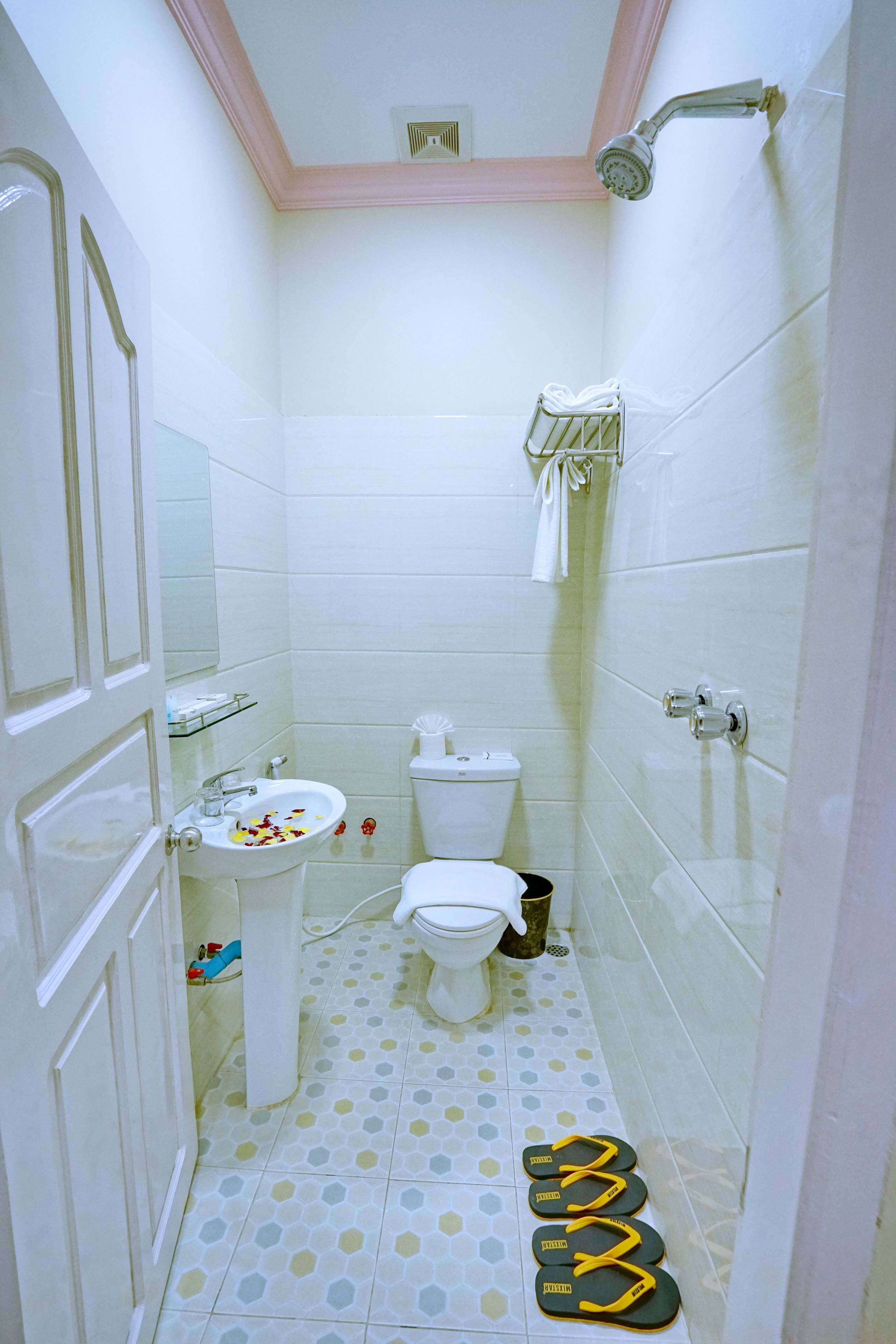 A small bathroom with a toilet, sink, and shower.