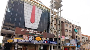 Ein Gebäude mit einem großen Schild für Santosh Plus Family Dhaba, das einen auffälligen roten Pfeil zeigt.