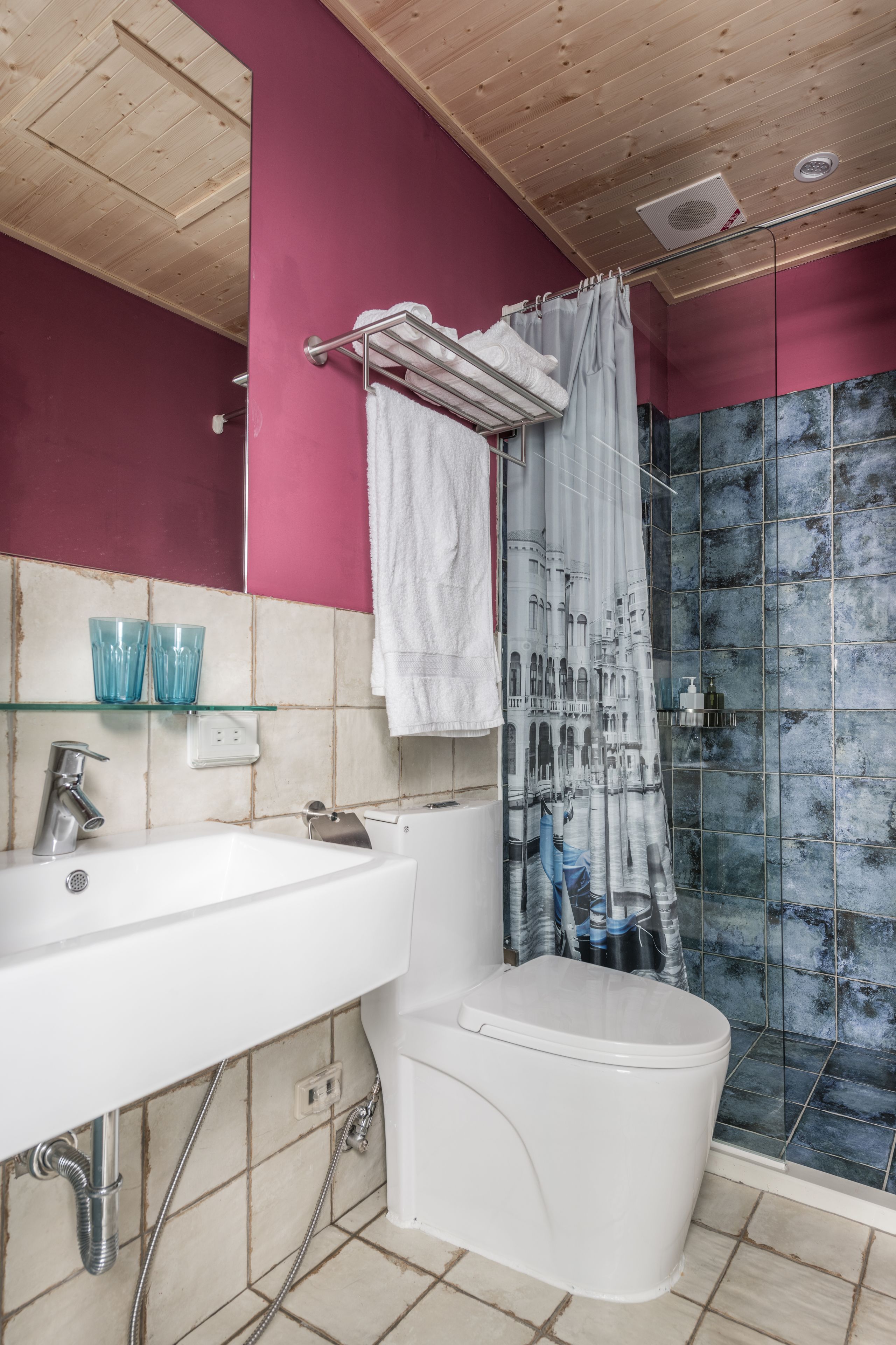 A bathroom with a white sink, a toilet, and a shower with a glass door.