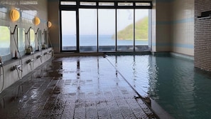 A wet indoor swimming pool with a view of the sea through large windows. - Ryokan Asamushi Onsen Hotel Akitaya (Aomori)