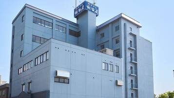 A multi-story building with a flat facade, several windows, and a sign with Japanese characters.