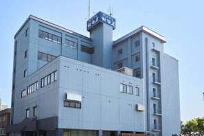 A multi-story building with a flat facade, several windows, and a sign with Japanese characters. - Ryokan Asamushi Onsen Hotel Akitaya (Aomori)