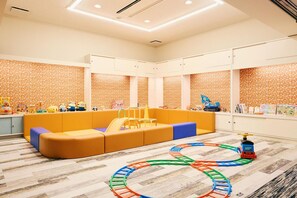 A children's play area with a colorful train track, a cushioned seating area, and a patterned wall. - Ryokan Asamushi Onsen Hotel Akitaya (Aomori)