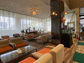 A hotel lobby with seating areas, a reception desk, and a large mirror reflecting the interior. - Ryokan Asamushi Onsen Hotel Akitaya (Aomori)