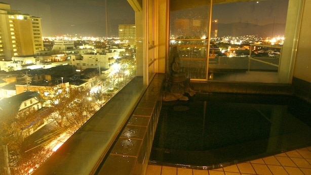 A high-rise building with a view of a cityscape at night.