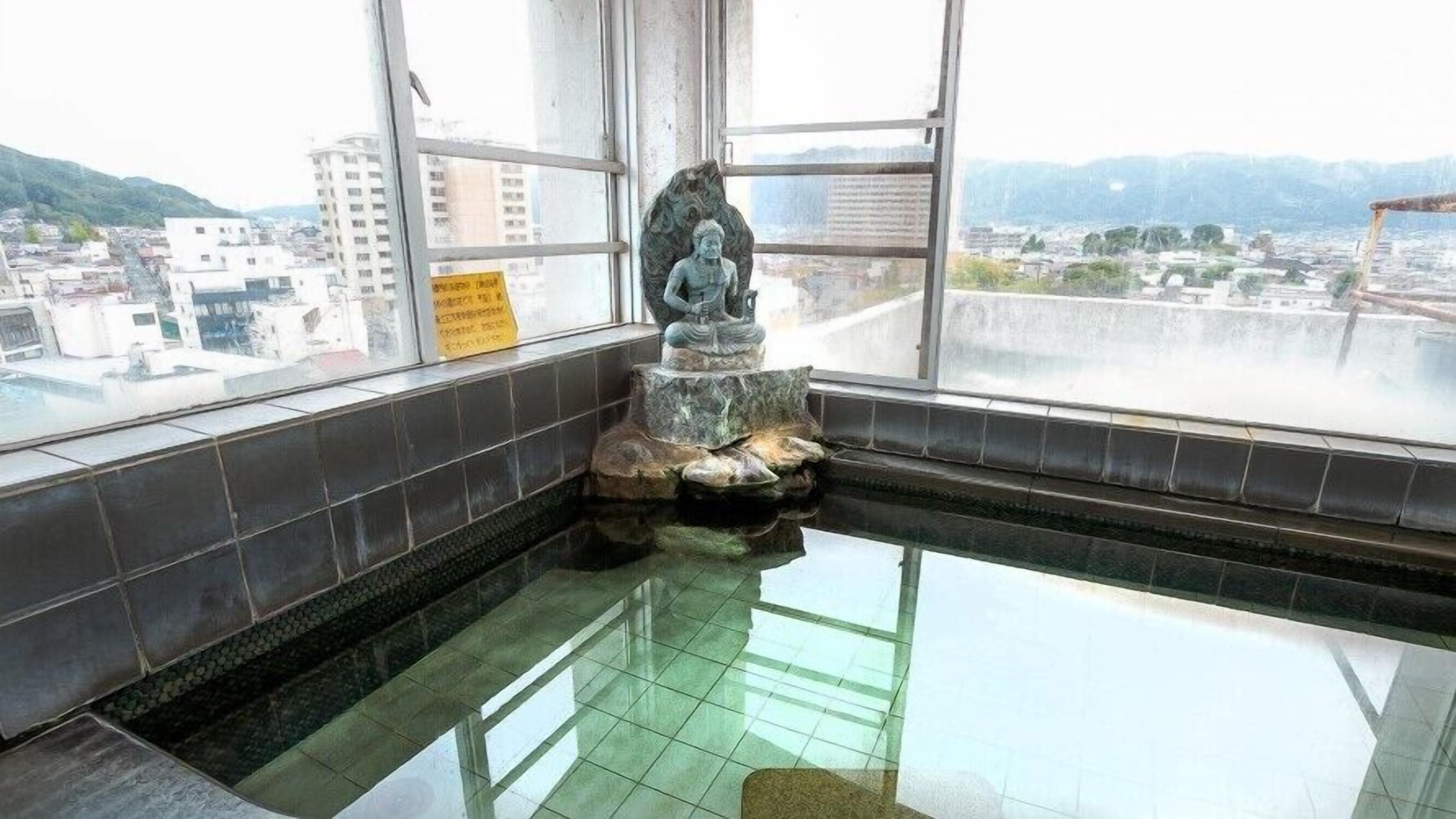 Ein Zimmer mit einem großen Fenster, einer Statue und einem gefliesten Boden.