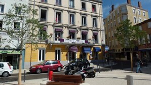 A hotel with a yellow facade, multiple balconies, and a sign reading "HOTEL DU MIDI". - Hotel du Midi (Annonay)