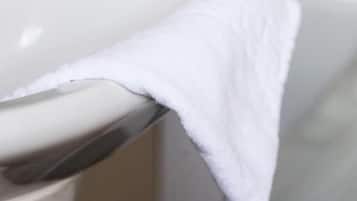 A bathroom with a white sink and a towel hanging on a rack.