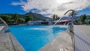 A swimming pool with clear blue water, surrounded by a concrete deck and metal railings. - Rescator Resort 208 - One Bedroom Apartment, Sleeps 4 (Roses)
