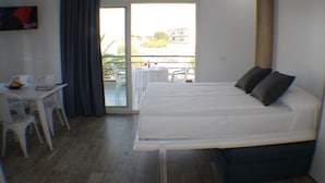 A hotel room with a bed, a small table, chairs, and a balcony with a table and chairs. - Rescator Resort 208 - One Bedroom Apartment, Sleeps 4 (Roses)