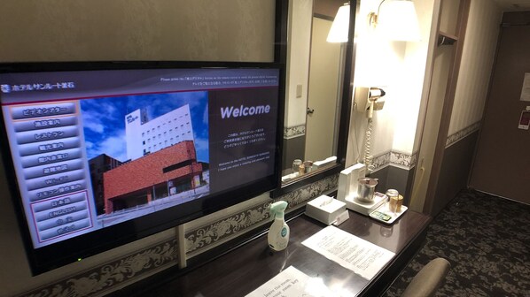 A hotel reception area with a digital display, a reception desk, a telephone, and a mirror. - Hotel Crown Hills Kamaishi (Kamaishi)