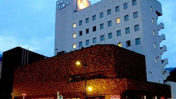 A hotel with a modern facade, multiple floors, and a prominent sign at the top.