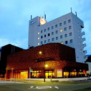 Un hotel con fachada moderna, varios pisos y un letrero llamativo en la parte superior.