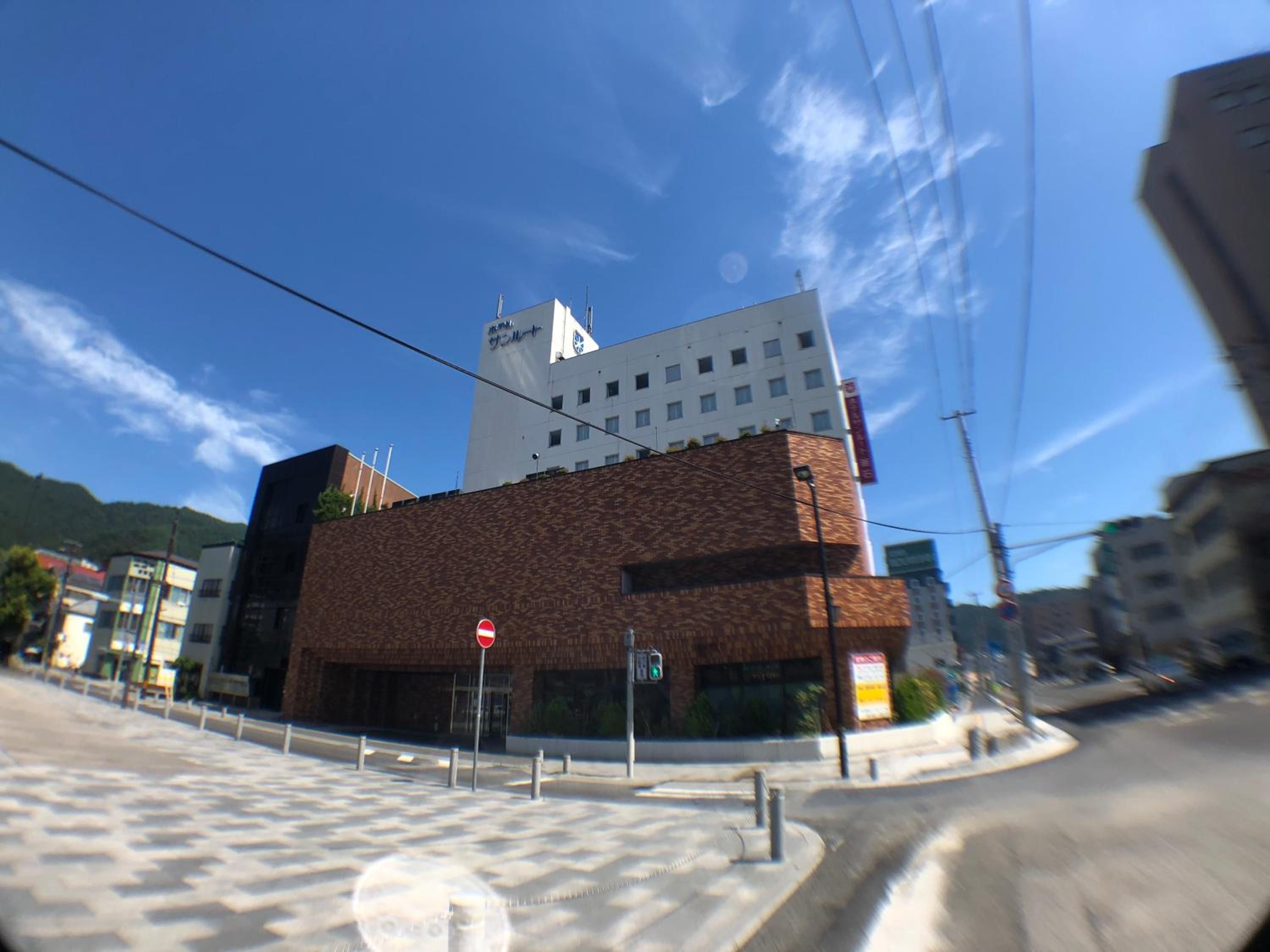 A building with a modern architectural design, featuring a prominent white and brown facade, and a visible traffic light.