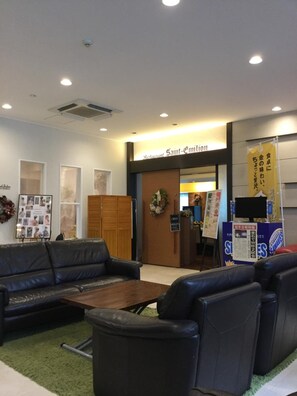 A lobby with a reception desk, a sign for 'Saint-Emilion Restaurant', and a banner with Japanese text. - Hotel Crown Hills Kamaishi (Kamaishi)