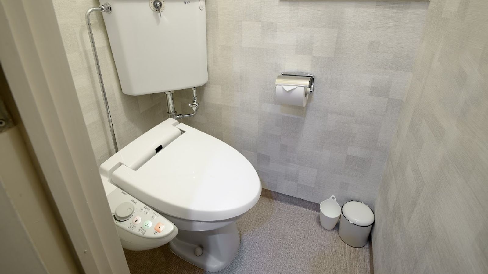 Un baño moderno con inodoro, bidé y dos papeleras.