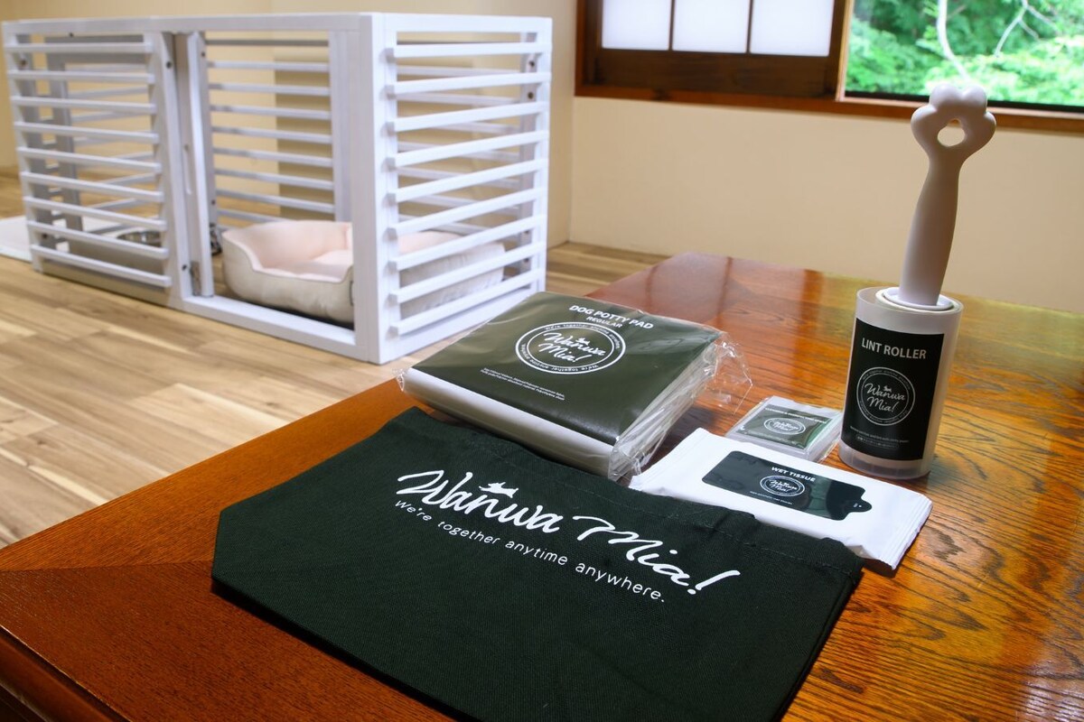 A wooden table with a dog bed, a lint roller, a dog toy, and a green cloth with text.