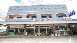 A two-story building with a cafe on the ground floor, outdoor seating, and a sign for a room service. - S3 Room (Sattahip)