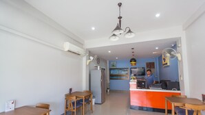 A modern kitchen with a central island, a dining area with wooden tables and chairs, and a bar area with a counter and seating. - S3 Room (Sattahip)