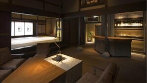 Amplia sala de estar con techo alto, chimenea y zona de estar con sofás y una mesa de centro.